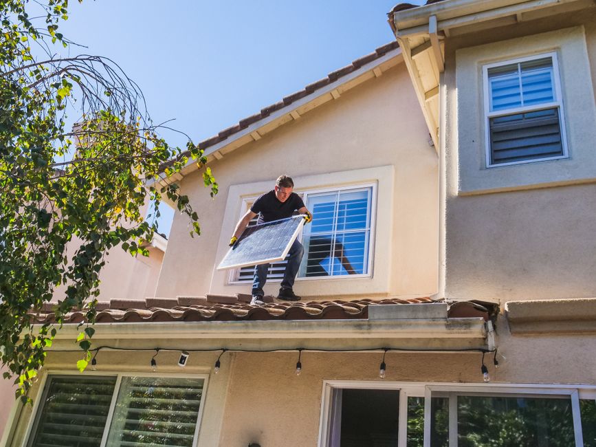 Workers fitting a window into the wall of a house during renovation